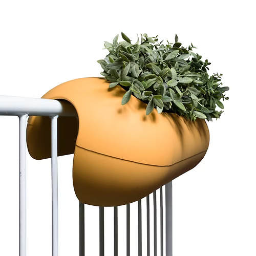 Ein skurriler gelber Pflanzkübel in Form eines Hotdogs, überquellend mit grünem Laub, befestigt an einem weißen Geländer.